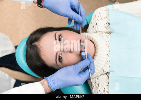 Patient liegt in den zahnmedizinischen Stuhl mit offenem Mund für die Inspektion Stockfoto