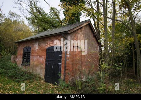 England Pumpraum in der Nähe des Ziegelgebäudes in den Wäldern Stalltür und Fenster Bootsleute lagern Lagerung verschlossen und verschlossen Unterholz Stockfoto