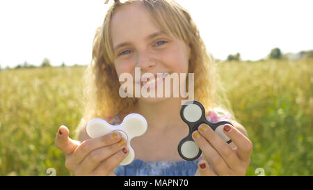 Das Mädchen hält Weiß, Blau und Schwarz Spinner. Anti-stress-Spielzeug entlasten. Stockfoto