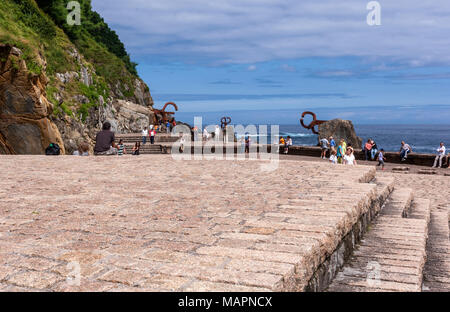 Touristen in den Kamm der Wind, San Sebastian, Peine del Viento XV, drei Skulpturen von Eduardo Chillida. San Sebastian, Spanien. Stockfoto