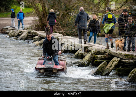 Ein Mann fährt ein Quad Bike durch den Fluss Barle bei Tarr Schritte im Exmoor National Park. Stockfoto