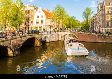 Ein Schiff, das unter eine Brücke über die Keizersgracht, Amsterdam, Niederlande, Europa Stockfoto