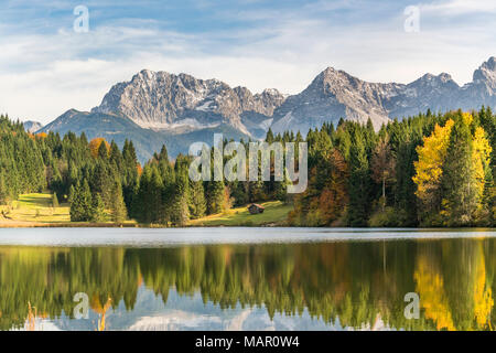 Lodge, Wald und Karwendel Alpen in den Gewässern von Gerold See, Krun, Oberbayern, Bayern, Deutschland wider. Stockfoto