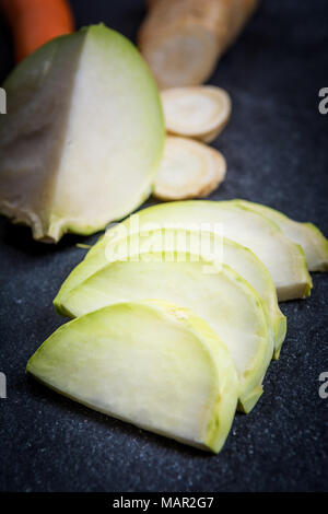 Kürzungen von Kohlrabi und Petersilie auf dunklem Stein Tabelle Stockfoto