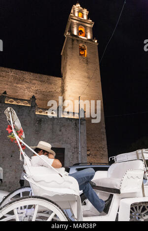 MERIDA, MEXIKO - 11. März 2012: Pferdekutsche Reiter am Abend city street in Merida, Yucatan, Mexiko ruhen Stockfoto