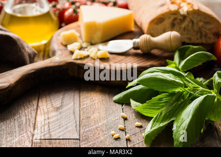 Italienisches Essen Hintergrund mit Parmesan, Olivenöl, Ciabatta und Basilikum auf rustikalen, mit Holz. Kopieren Sie Platz für Text, selektiver Fokus Stockfoto