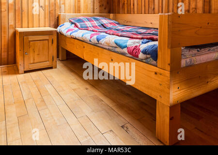 Schlafzimmer mit einem Bett in einem Chalet aus Holz. Stockfoto