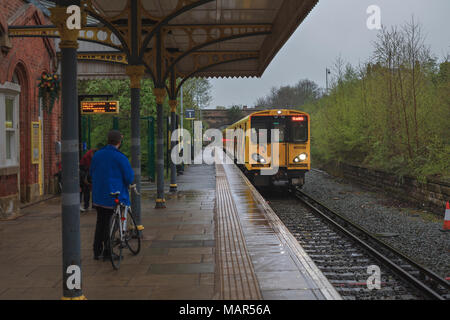 Ein merseyrail Zug in Ormskirk Bahnhof aus Liverpool mit einem Radfahrer warten in den Zug mit seinem Fahrrad zu Stockfoto