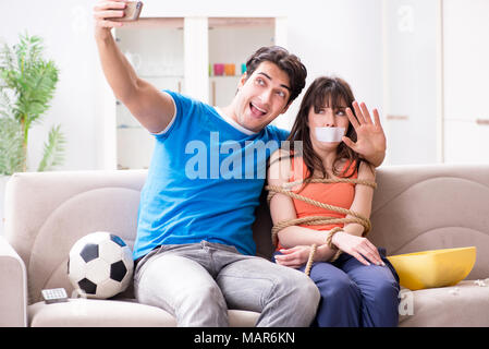 Mann binden bis seine Frau zur sportschau Fußball Stockfoto