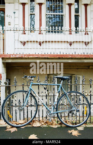Bike neben einem Zaun und Angekettet in Newcastle, NSW geparkt Stockfoto