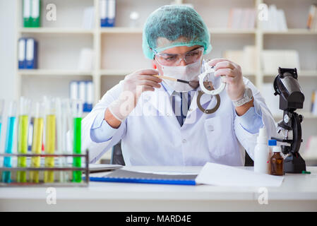Kriminologen Polizei Chemiker bei der Kriminalität Beweise suchen Stockfoto
