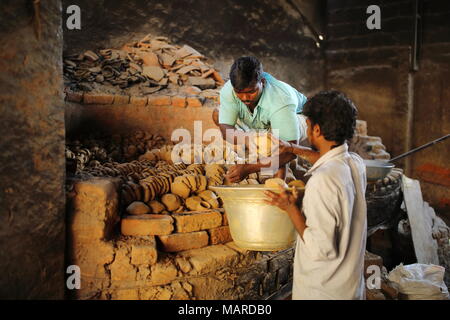 Bangalore, Indien - 15. Oktober 2016: Unbekannte arbeit Anordnen der getrockneten Steingut für die Wärmebehandlung die Objekte als letzter Prozess zu stärken. Stockfoto