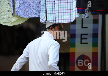 Bangalore, Indien - 16. Oktober 2016: Unbekannter Musllim Mann steht seine Zunge dehnen in einer seltsamen Art und Weise vor einem Tuch shop Residency Road. Stockfoto