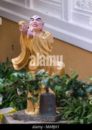 Hacienda Heights, CA, USA - 23. März 2018: Nahaufnahme von Golden drapiert Kanakabharadvaja mit bown in Arhat Garten bei Hsi Lai buddhistischer Tempel. Grüne pl Stockfoto