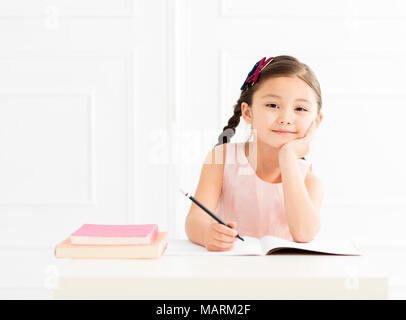 Kleines Mädchen mit Buch studieren zu Hause Stockfoto