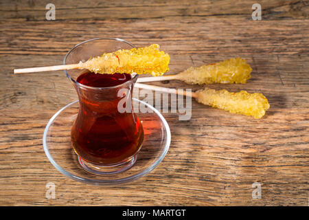 In der Nähe von Saffron Kandis Zucker Kristall an einer schwarzen Tee Tasse wird oft benutzt, um in Kaffee in der Iranischen Persische Küche aufgelöst werden Stockfoto