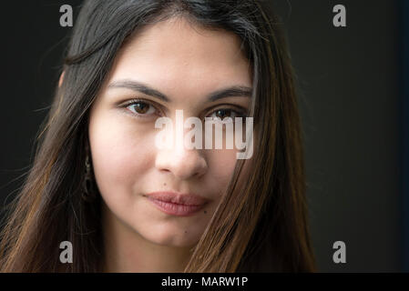 Closeup Portrait einer attraktiven jungen Frau. Outdoor Portrait von einer schönen Frau, schwarze Wand im Hintergrund. Stockfoto