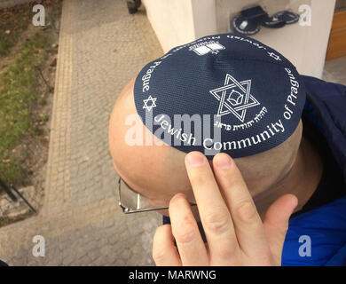 Besucher seinen Kopf deckt mit der kippa vor dem Besuch des Neuen Jüdischen Friedhof (Starý židovský hřbitov) im Stadtteil Žižkov in Prag, Tschechische Republik. Stockfoto