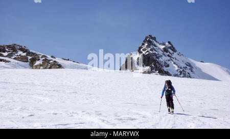 Männliche backcountry Skier einen Berg klettern an einem schönen Wintertag in den Alpen in der Nähe von St. Moritz Stockfoto