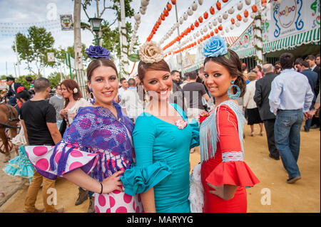 Junge Frauen in bunten Flamenco-Kleider auf der Sevilla April Messe, Spanien Stockfoto