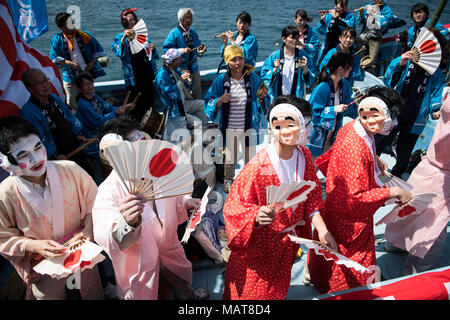 NUMAZU, JAPAN - 4. APRIL: ein Boot Last von dancing Fischer mit ihren Gesichtern in Pulverform weiß und gekleidet mit Frauen Roben im Mittelpunkt des Uchiura Fischereihafen während Ose Matsuri/Festival in der osezaki Bezirk Numazu, Präfektur Shizuoka am April 4, 2018, Japan statt. Quelle: Lba Co.Ltd./Alamy leben Nachrichten Stockfoto