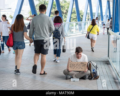 Hong Kong, Hong Kong SAR, China. 4 Apr, 2018. HONG KONG, Hong Kong SAR, China: 4. April 2018. Kaukasische Bettler auf den Straßen von Hong Kong. Es hat eine Zunahme der kaukasischen Bettler, die Geld zu reisen, oder behaupten, sie mit Unglück getroffen haben. Sie sitzen in der hohen touristischen Gebieten wie der Gehweg zwischen dem Apple Store und die Star Ferry Credit: Jayne Russell/ZUMA Draht/Alamy leben Nachrichten Stockfoto