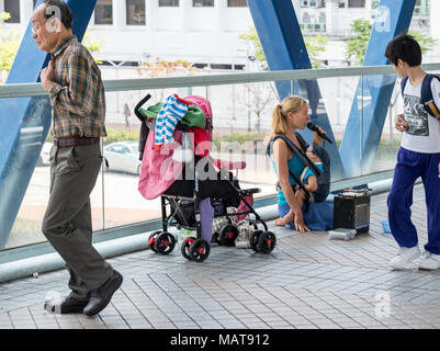 Hong Kong, Hong Kong SAR, China. 4 Apr, 2018. HONG KONG, Hong Kong SAR, China: 4. April 2018. Kaukasische Bettler auf den Straßen von Hong Kong. Es hat eine Zunahme der kaukasischen Bettler, die Geld zu reisen, oder behaupten, sie mit Unglück getroffen haben. Sie sitzen in der hohen touristischen Gebieten wie der Gehweg zwischen dem Apple Store und die Star Ferry Credit: Jayne Russell/ZUMA Draht/Alamy leben Nachrichten Stockfoto