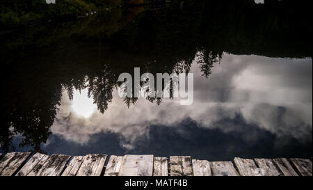 Die Reflexion der Sonne im Klaren, noch Wasser von Fichte See (South Chilcotin Mountains Park) als aus dem Dock gesehen. (BC, Kanada) Stockfoto