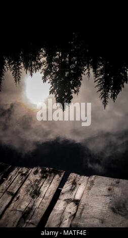 Die Reflexion der Sonne im Klaren, noch Wasser von Fichte See (South Chilcotin Mountains Park) als aus dem Dock gesehen. (BC, Kanada) Stockfoto