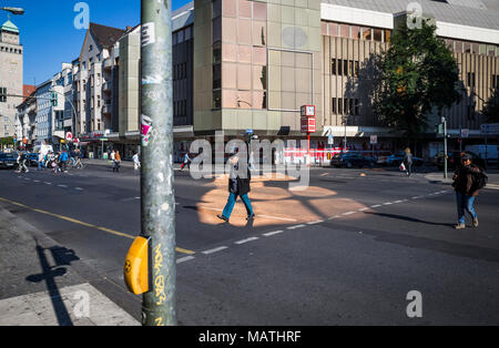 Fußgänger die Straße überqueren, durch eine Pfütze von Reflektierten goldenen Licht in Berlin, Deutschland. Stockfoto