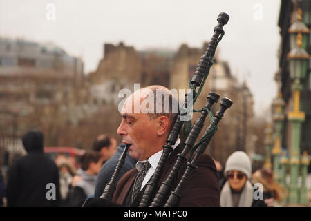 Eine straßenmusik Dudelsackpfeifer spielen auf die Westminster Bridge, London die vorbeiziehenden Passanten zu unterhalten Stockfoto