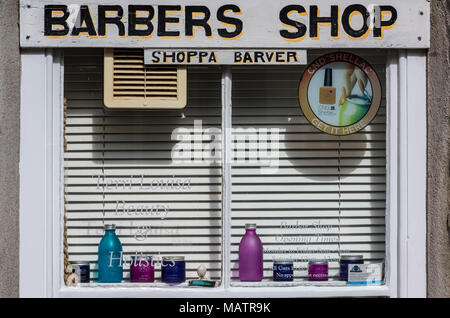 Das Fenster eines Friseure shop in einem traditionellen Gebäude in St Ives in Cornwall. Haare schneiden und Salons mit Werbung im lokalen Dialekt Cornwall Stockfoto