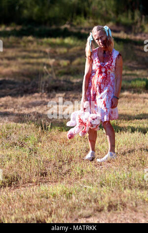 Ein älterer Mann verkleidet als blutiger Zombie in einem Feld steht, zu bedrohen Schienen im Lauf um dein Leben 5 k am 14. September 2013 in Dalton, GA warten. Stockfoto