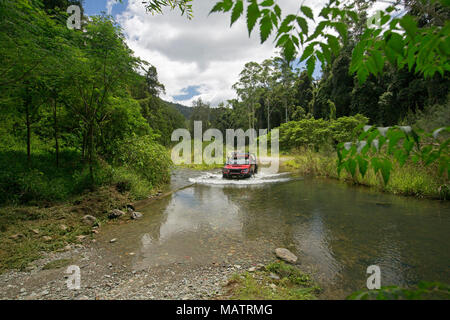 Red Allradantrieb Fahrzeug Kreuzung Creek mit smaragdgrünen Wäldern in Conondale Ranges National Park Queensland Australien gesäumt Stockfoto