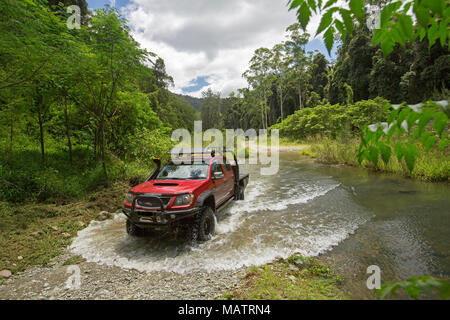 Red Allradantrieb Fahrzeug Kreuzung Creek mit smaragdgrünen Wäldern in Conondale Ranges National Park Queensland Australien gesäumt Stockfoto