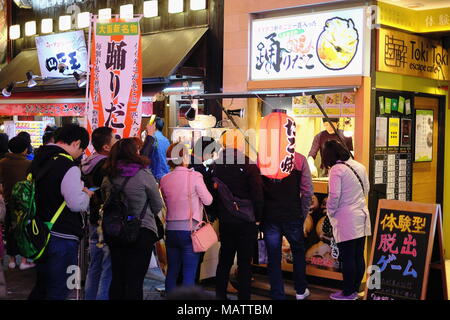 Leute, für die Verkleidung Street Food stall in Osaka Stockfoto