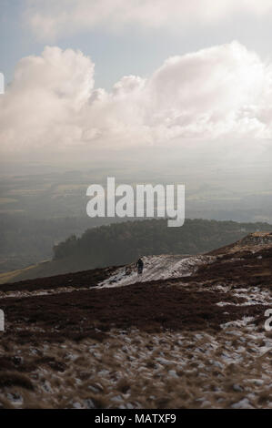 Ein Mann uphill Radfahren auf einem Pfad in den verschneiten Pentlands Hügeln in der Nähe von Edimburgh Stockfoto