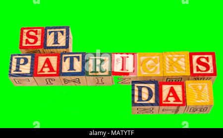 Der Begriff St Patrick's Day visuell dargestellt auf einem smaragdgrünen mit bunten Holzspielzeug Bausteine Bild Hintergrund im Querformat. Stockfoto