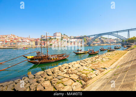 Porto, Portugal - 13 August, 2017: die malerischen alten Oporto Waterfront mit Ribeira Skyline. Ein traditionelles rabelo Boote auf dem Fluss Douro mit Dom Luis I Brücke von Vila Nova de Gaia, Porto. Sonnigen Tag. Stockfoto