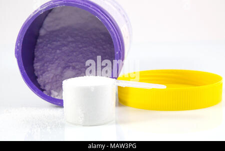 Produkt der weißen Waschpulver in einem Messbecher auf weißem Hintergrund Stockfoto