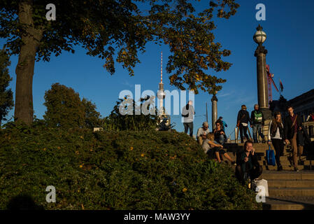 Die Menschen genießen den späten Sommer Sonne auf Schritte am Ufer der Spree in Berlin, Deutschland. Stockfoto