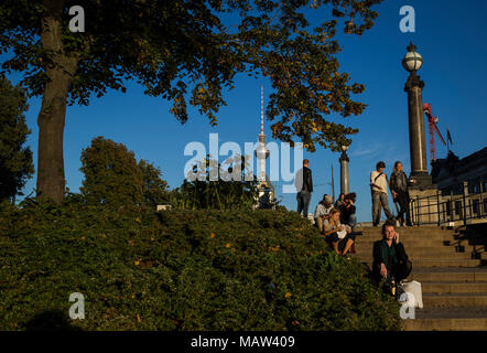 Die Menschen genießen den späten Sommer Sonne auf Schritte am Ufer der Spree in Berlin, Deutschland. Stockfoto