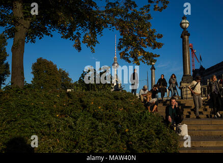 Die Menschen genießen den späten Sommer Sonne auf Schritte am Ufer der Spree in Berlin, Deutschland. Stockfoto