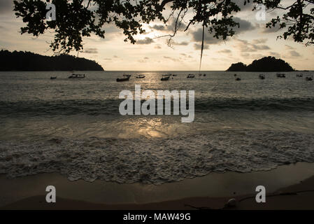 Panorama Blick auf den Sonnenuntergang und die Silhouette von Bäumen und Boote am Strand in Teluk nipah Strand in Pangkor Island gelegen, Pulau Pangkor, Perak, Malaysia Stockfoto