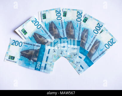 Neue Norwegische zwei hundert Kronen Banknoten schwärmten aus, auf einem weißen Hintergrund die Cod/skrei wichtig für die Wirtschaft im Wandel der Zeiten Stockfoto