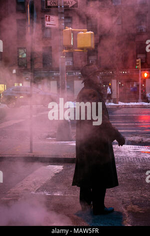 Ein Mann mit einem Fedora auf einem dampfenden Straße in New York City. Stockfoto