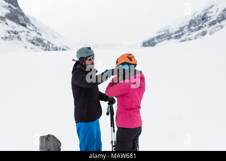 Paar tragen Helm auf einem schneebedeckten Berg Stockfoto