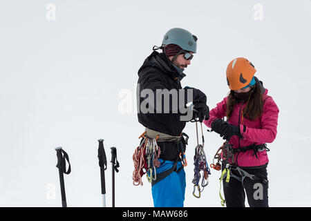 Paar tragen Kabelbaum auf einem schneebedeckten Berg Stockfoto