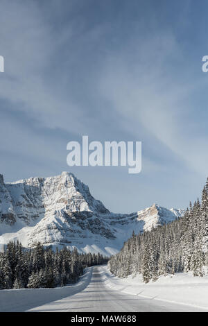 Verschneite Straße durch die schneebedeckten Berge Stockfoto