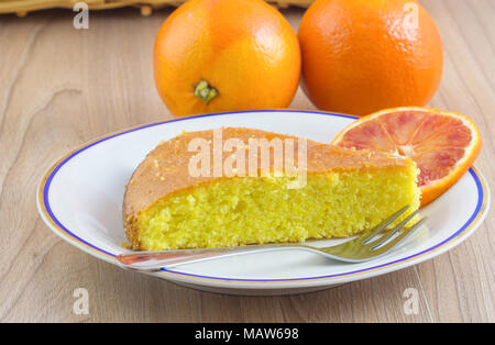 Kuchen, hausgemachten Kuchen kommen aus Zitrusfrüchten und orange Folie in der Platte auf Holz Tisch Hintergrund. Stockfoto